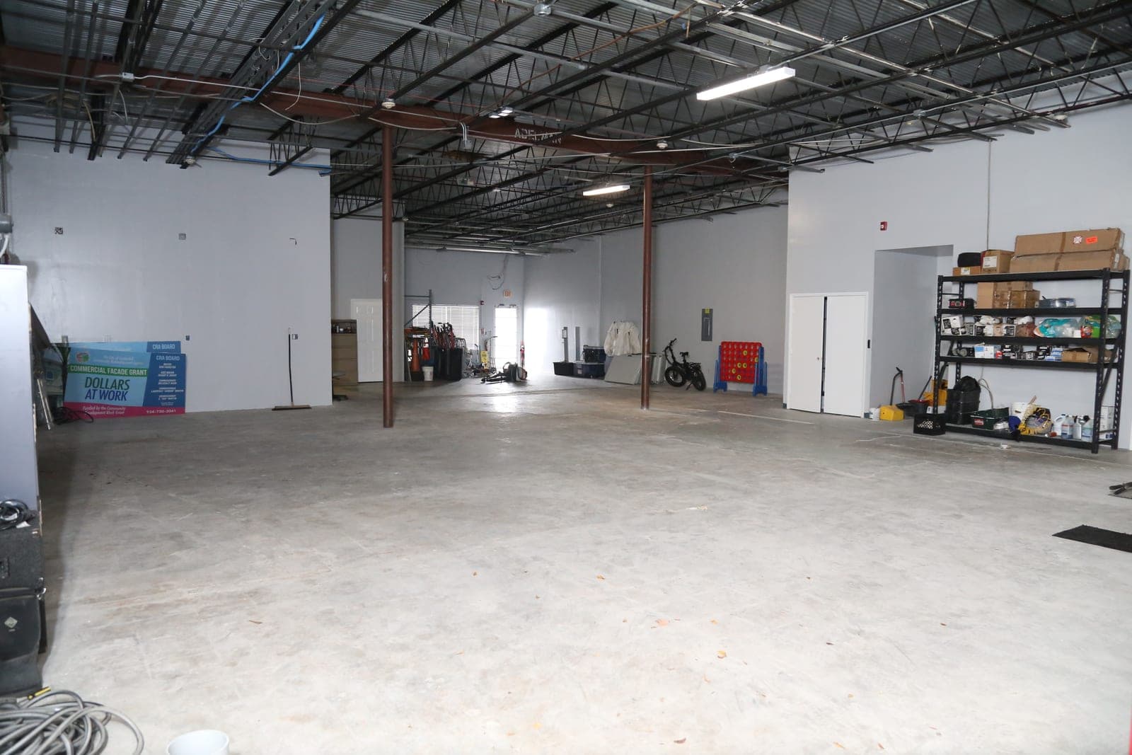 Open garage and storage area with exposed ceiling trusses at 1883