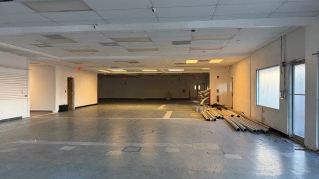 Deep open interior commercial space with drop ceiling at 1883