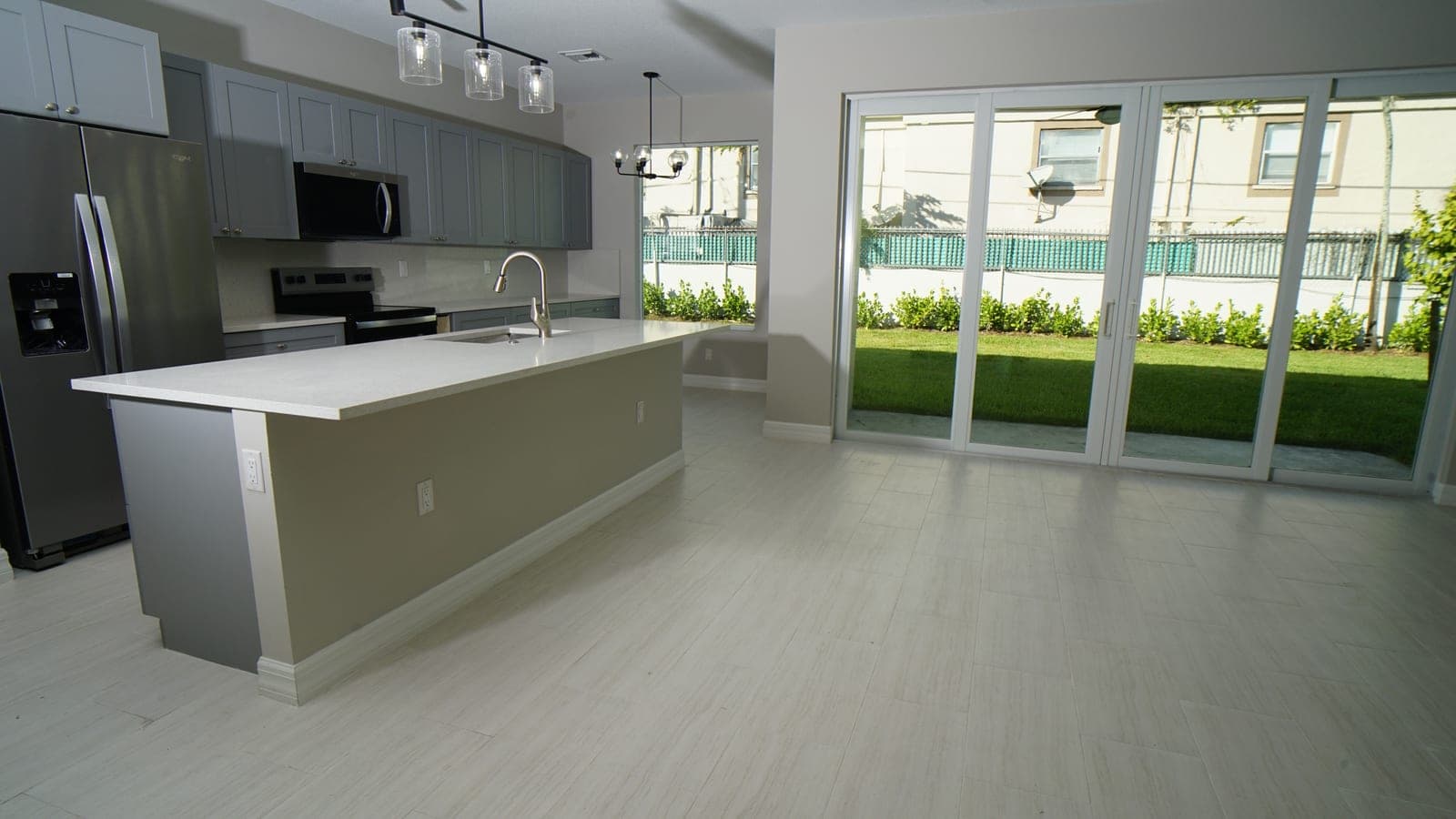 Kitchen and living area with center island and sliding glass doors